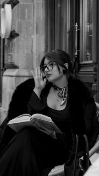 Azerbaycan'ın Bakü şehrinde, siyah kürklü palto giymiş şık bir kadın sokakta kitap okuyor.